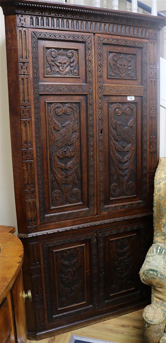 A George III oak corner cupboard, with later carving, W.108cms H.204cms